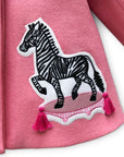 Close-up of zebra appliqué on Yolanda and Tatty pink wool coat, featuring embroidered details and pink tassels.