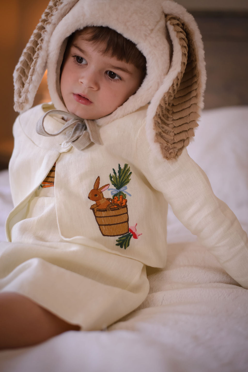 Toddler wearing Little Goodall embroidered linen bunny jacket with bushel basket design. Lightweight, heirloom-quality cardigan for boys and girls