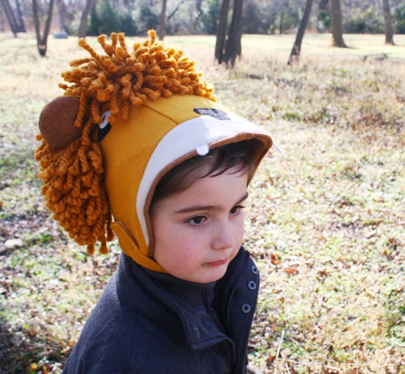 Toddler wearing a cozy wool-blend felt lion hat with curly mane and adjustable chin strap for warmth and play.