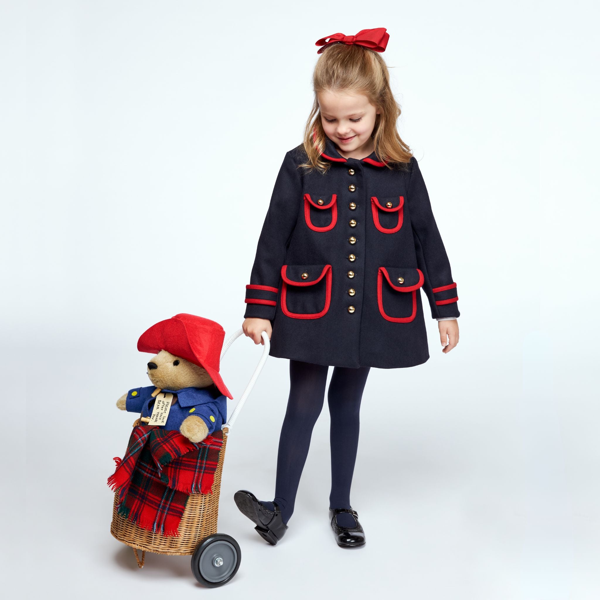 Girls dark blue winter coat with red trim, gold buttons, and A-line design. Stylish wool-blend coat for cold weather