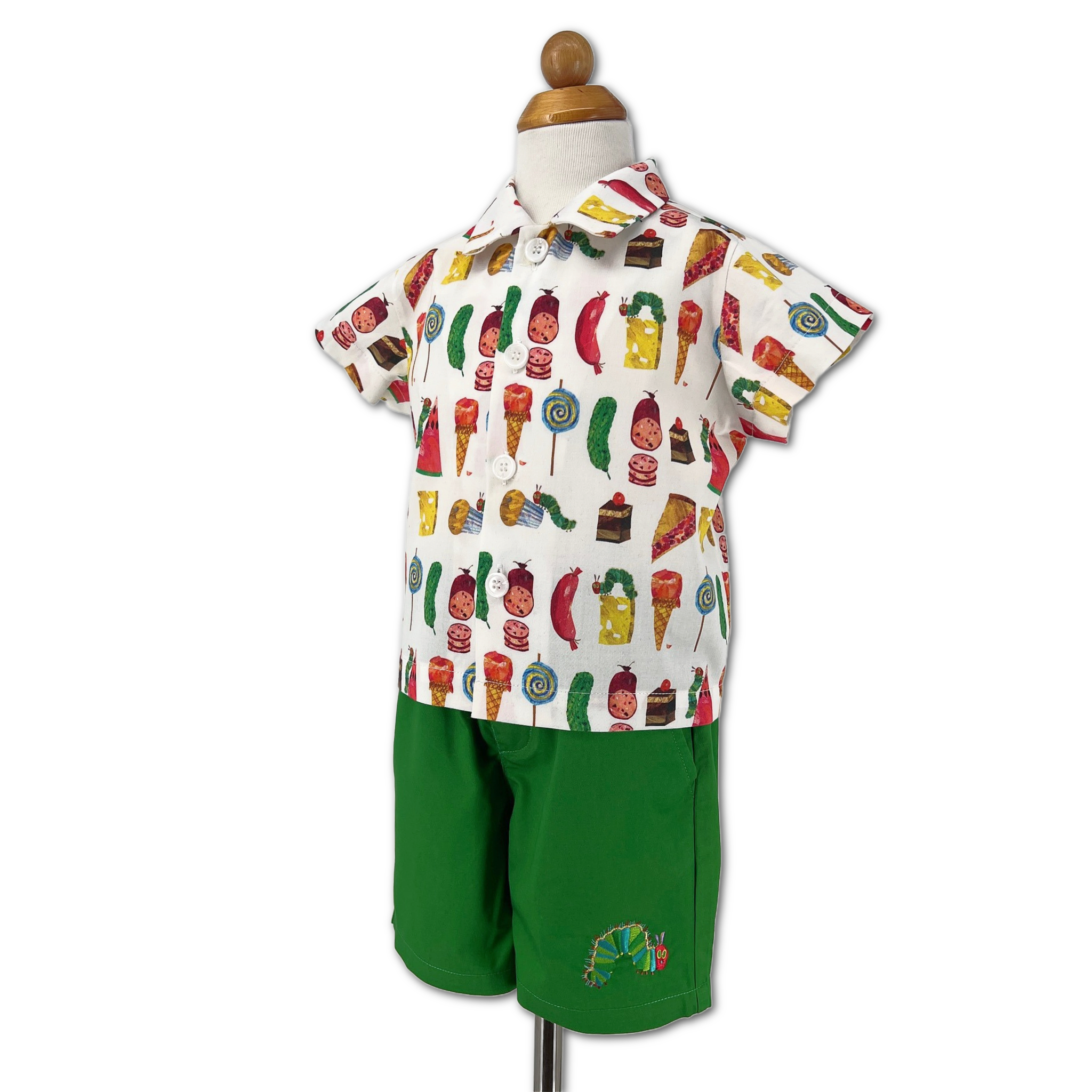 Kids’ Hungry Caterpillar clothing set on form, including bright green shorts with embroidery and a short-sleeve food print top