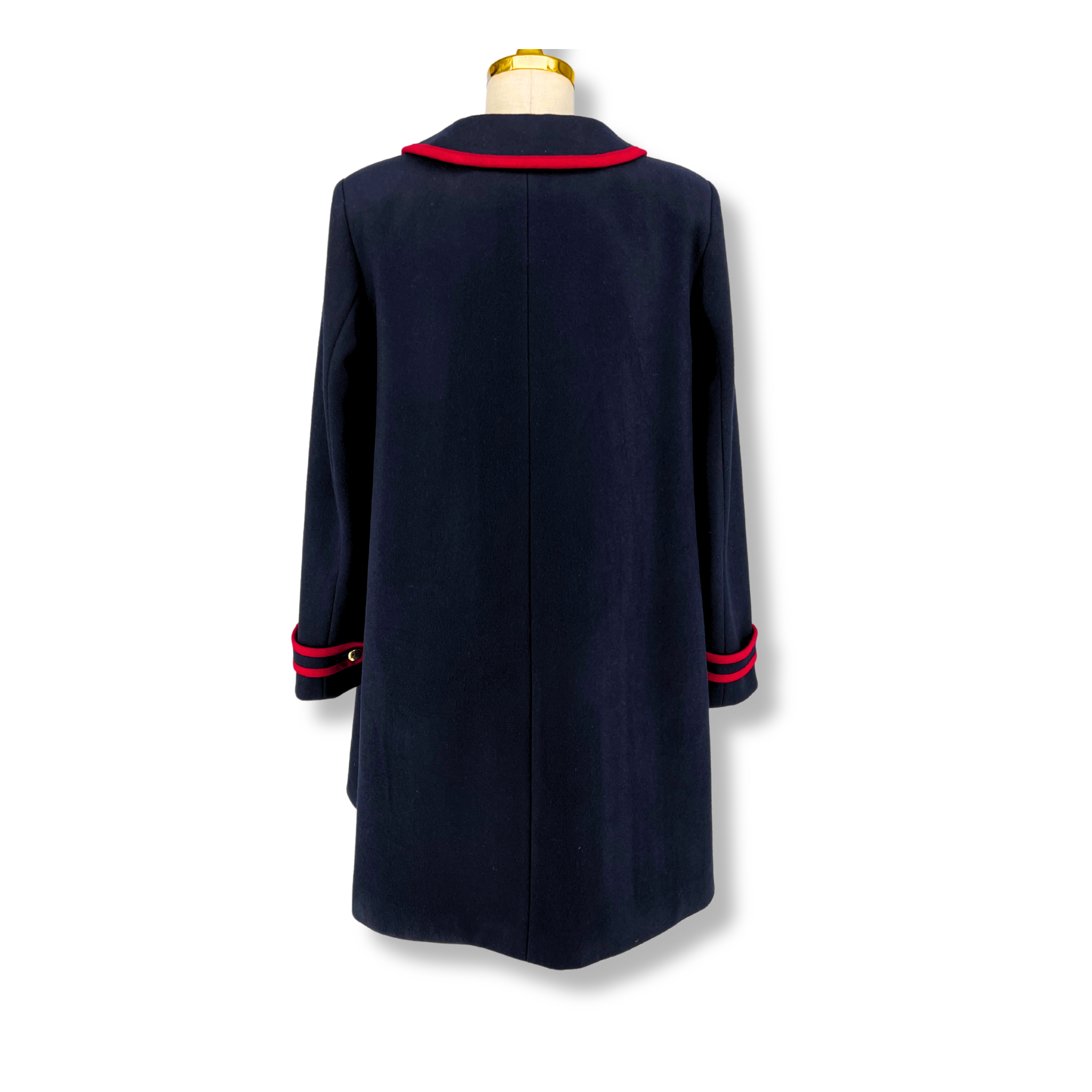 Back view of a womens deep blue wool coat with red trim and a tailored A-line silhouette.
