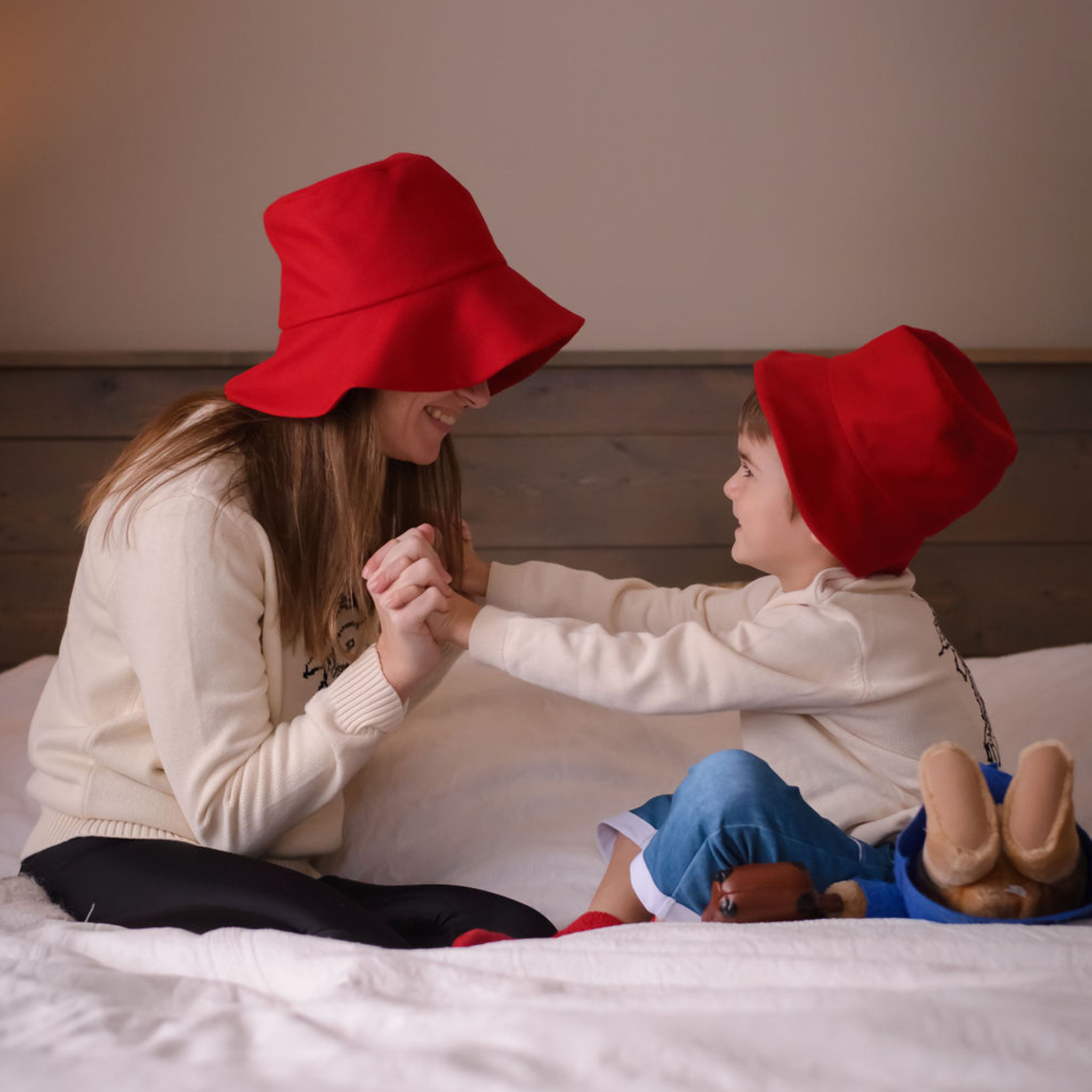 Mother and child wearing matching red wool bucket hats 