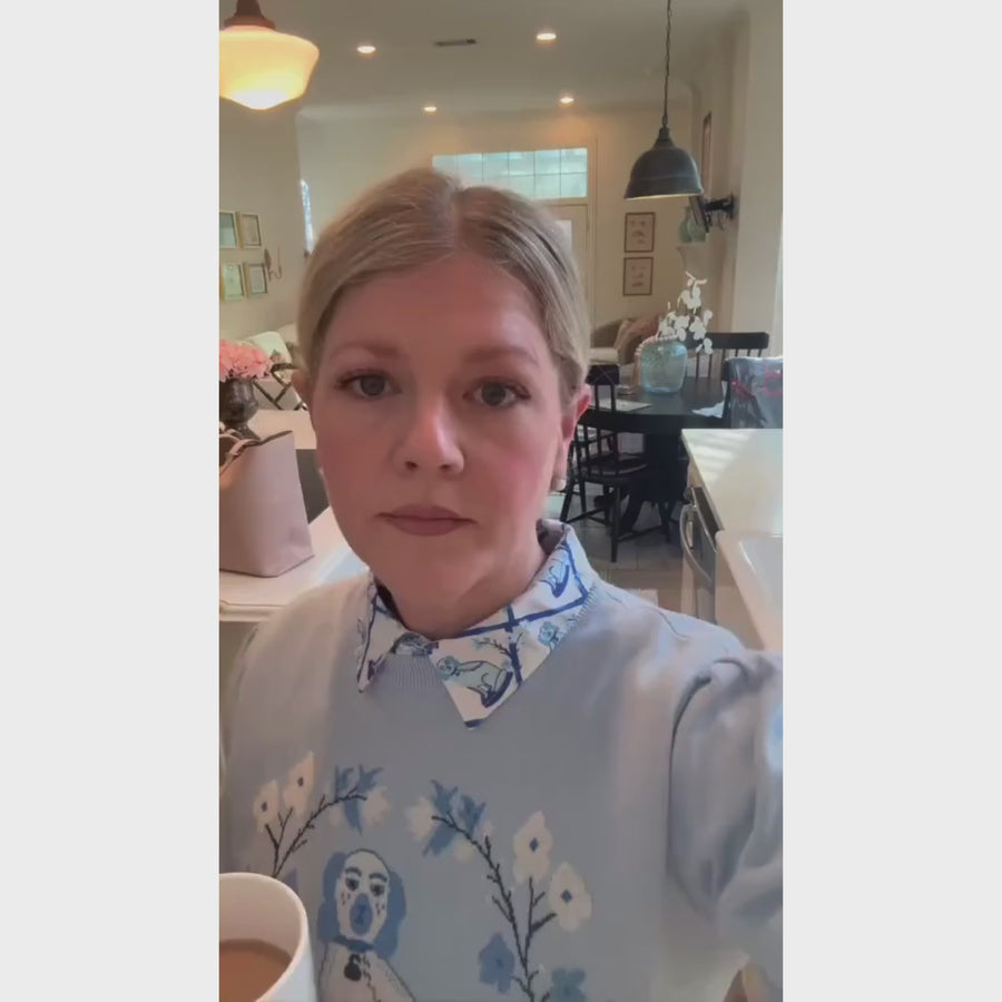 Lady showcasing her Willa Heart blue dog sweater styled with a classic printed Willa Heart shirt for a polished and preppy layered look