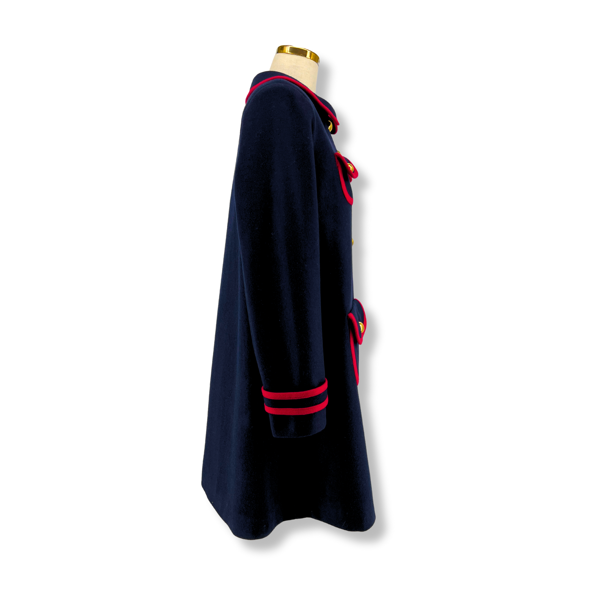 Side view of a women's deep blue wool winter coat with red trim and gold buttons. 