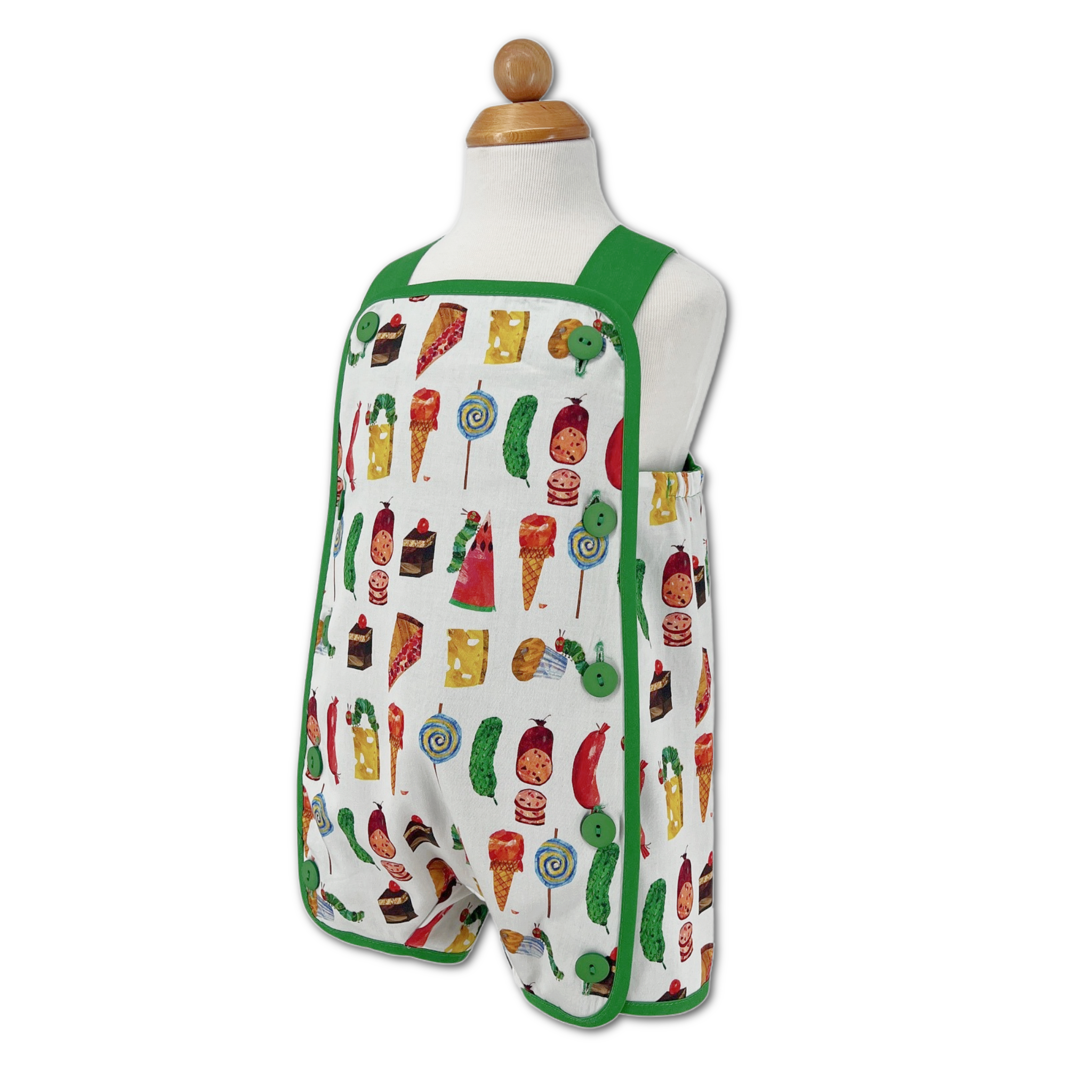 Side view of a reversible Hungry Caterpillar toddler romper, on form showcasing colorful food-themed fabric.