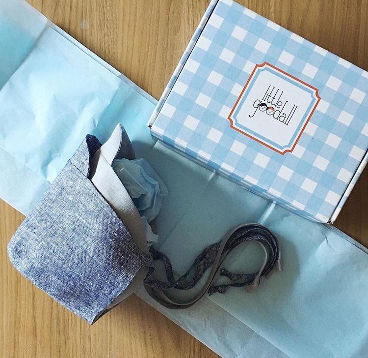Little Goodall baby bonnet in blue linen, beautifully wrapped in tissue paper with a gingham gift box, perfect for gifting newborns and toddlers
