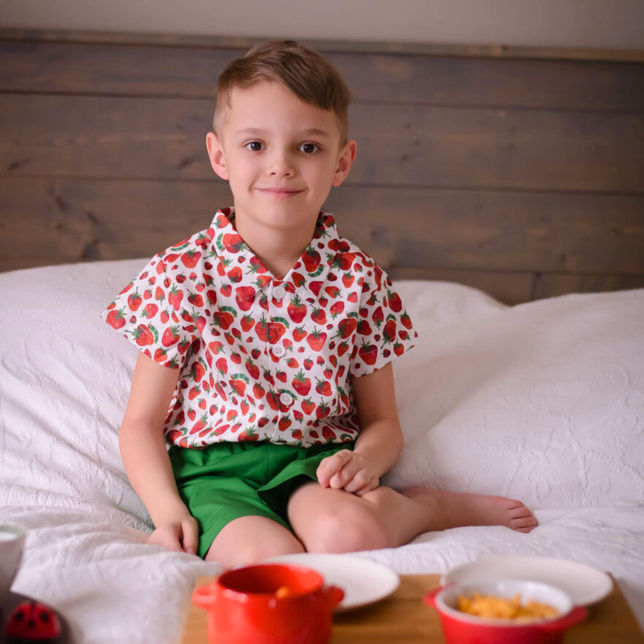 Child wearing a short-sleeve button-up strawberry print shirt from The Very Hungry Caterpillar collection, made of breathable cotton