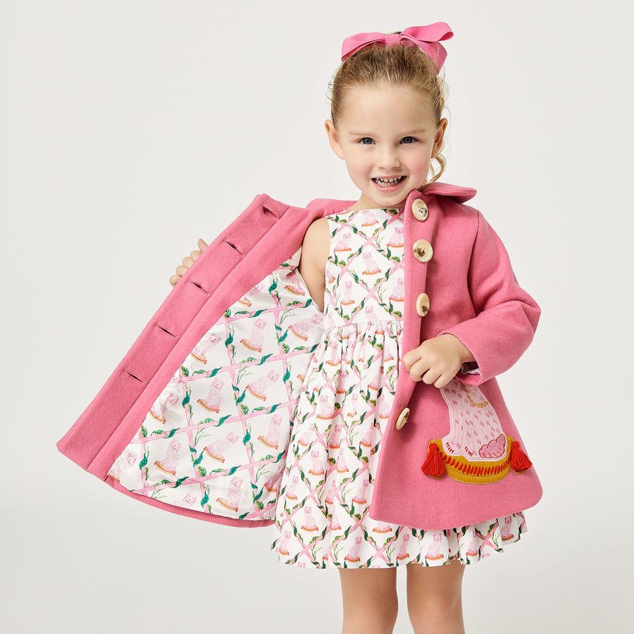Model wearing pink dog coat, exposing the pink dog satin lining.