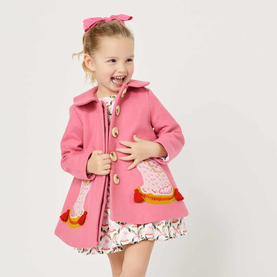 Model wearing pink dog coat, exposing four buttons down the front.