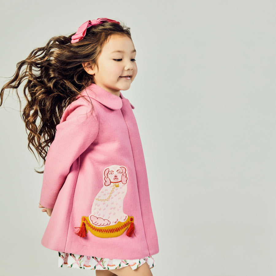 Model wearing Pink dress coat with dog on side