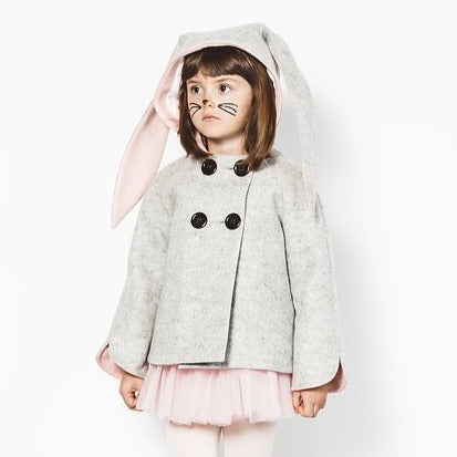 Model wearing grey bunny coat with hood up and floppy bunny ear pink lining visible.