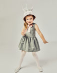 Front view of girl modeling a Unicorn hat tied as a bow underneath her chin.