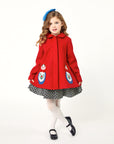 Girl modeling red coat while curtsying.