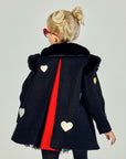 Back view of black coat displaying red center to the center back pleat. Along with three hearts scattered across the back.