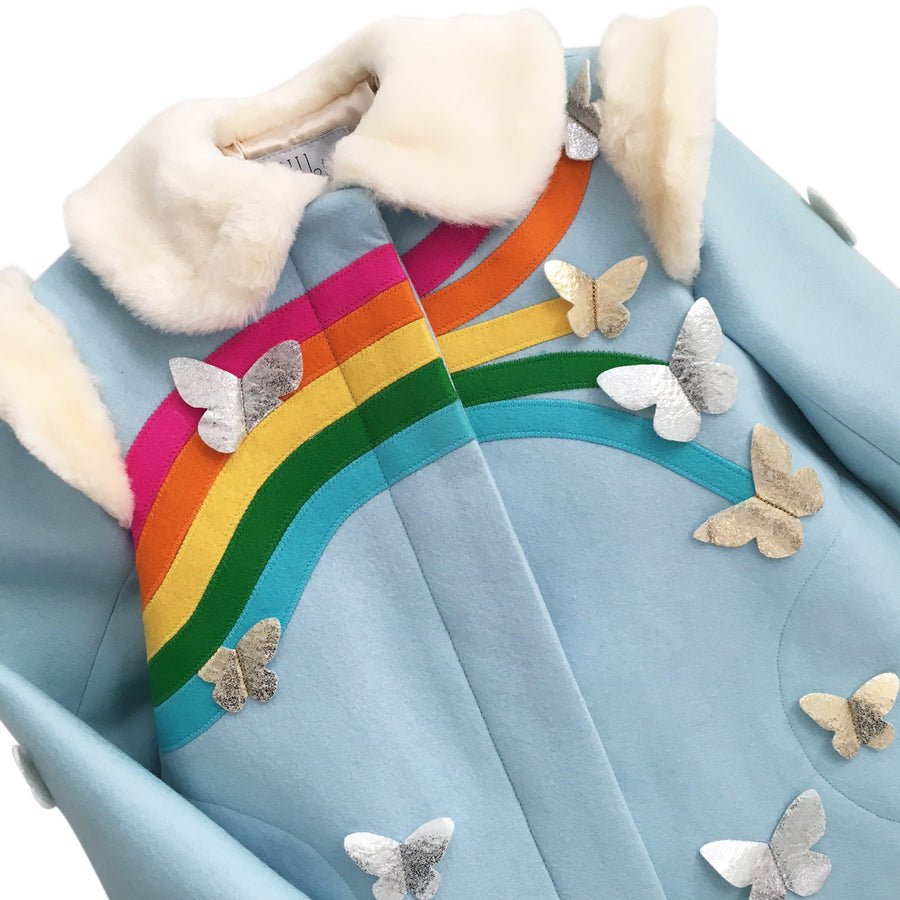 Closeup on the blue coat, displaying the rainbow with different sized butterflies at the end of each color. 