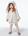 girl modeling grey bunny coat, with hood up, displaying floppy ears.