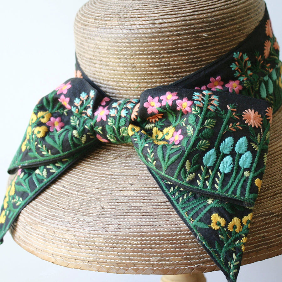 Close-up of colorful floral embroidery on wide black bow of Audrey Garden Hat