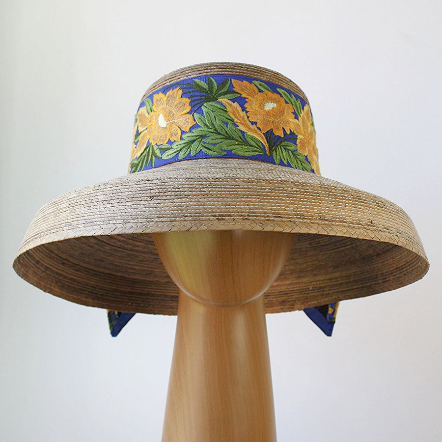 Front view of Audrey Sunflower straw hat featuring vibrant yellow floral embroidery on French blue trim
