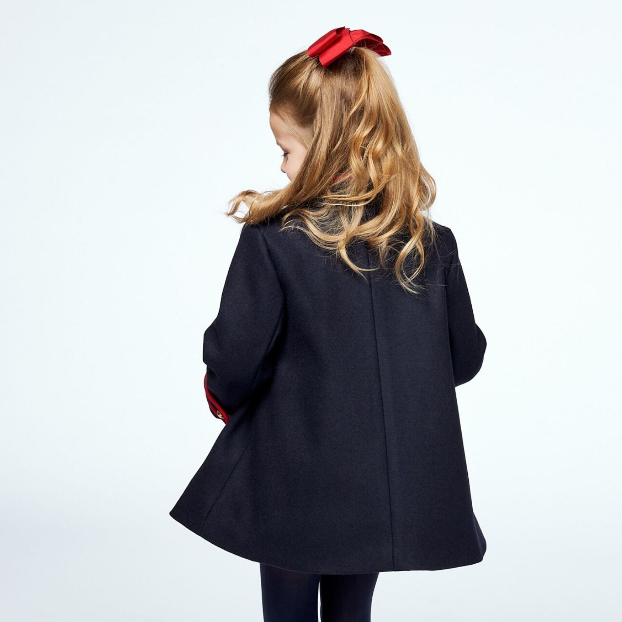 Elegant navy wool coat for girls by Little Goodall, showcasing the back pleat and refined tailoring