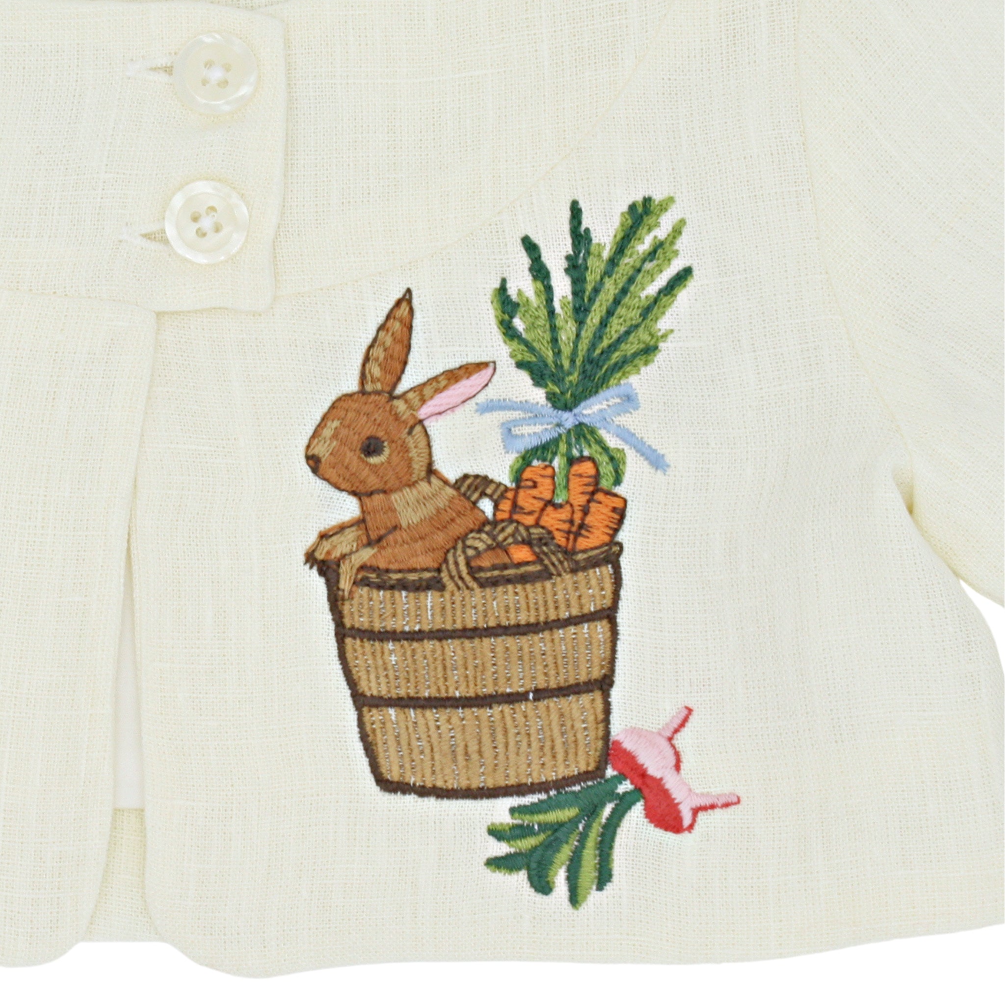 Close-up of embroidered bunny in a bushel basket with carrots and radishes on Little Goodall linen jacket. Fine heirloom-quality stitching detail.