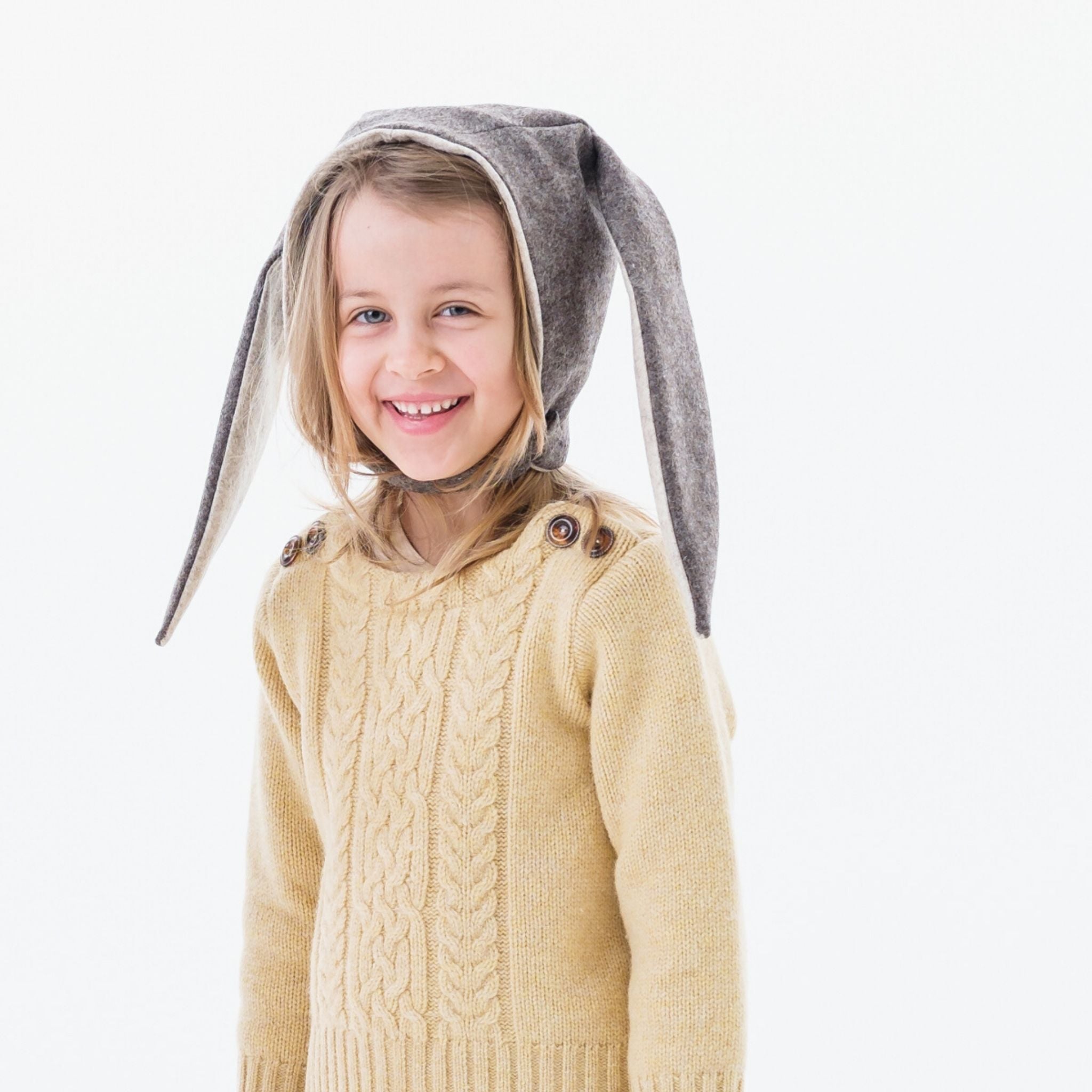 Child wearing a mushroom brown Flopsy Bunny Hat with floppy gray ears, wool blend felt, soft fleece lining, and a chin strap