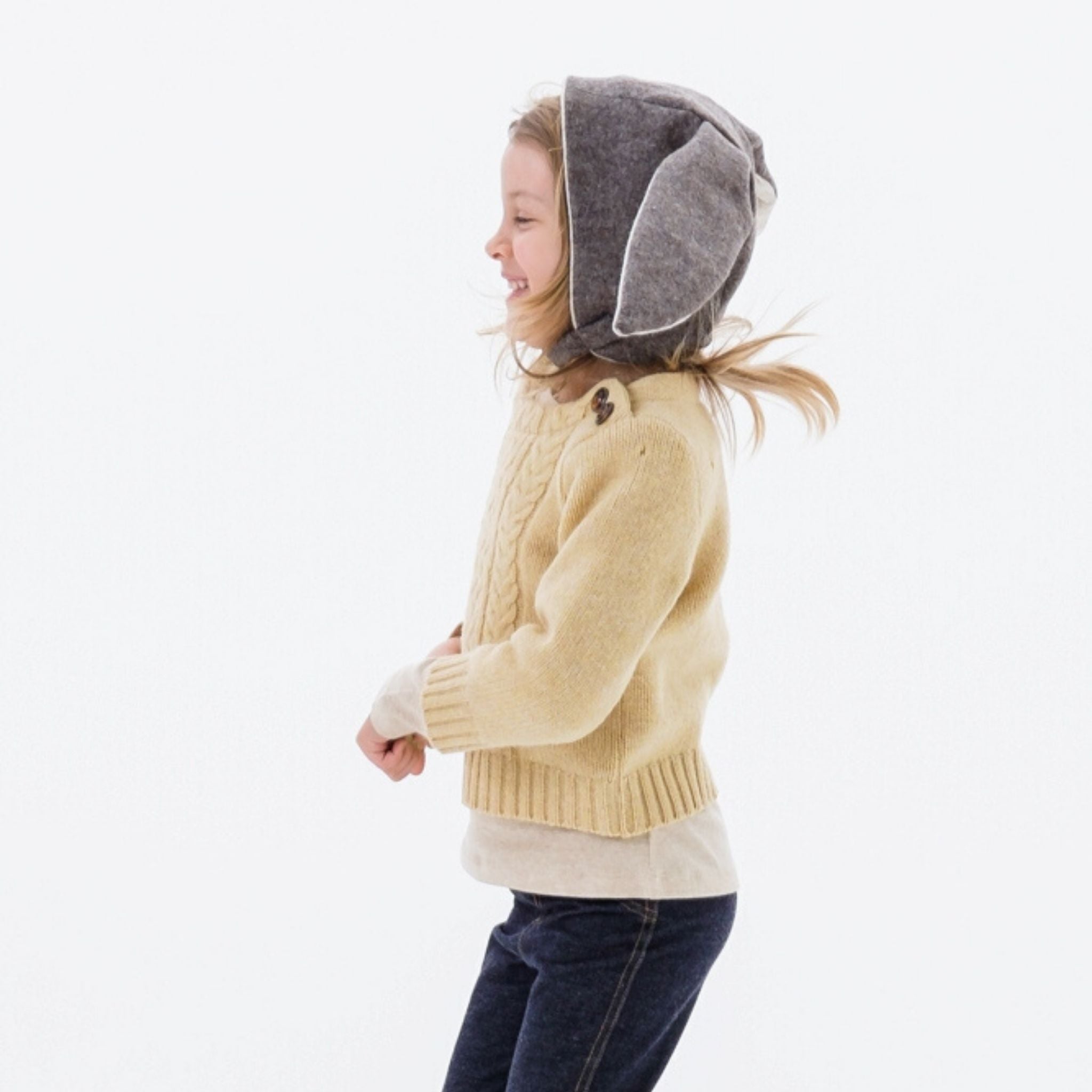 Child modeling the Flopsy Bunny Hat in mushroom brown wool with gray ears, soft fleece lining, and a secure chin strap