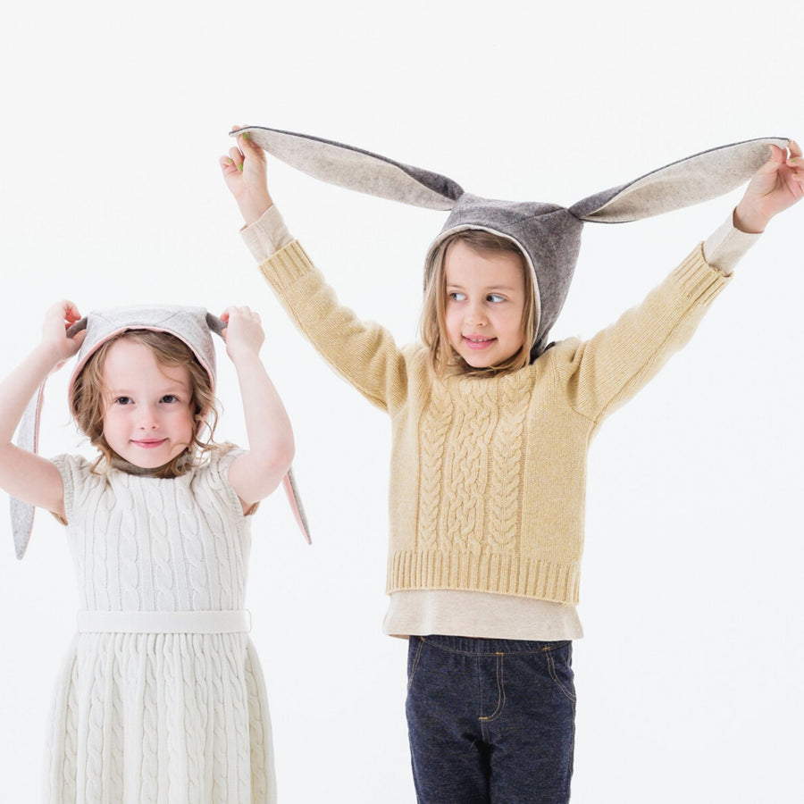 Two children wearing wool felt Flopsy Bunny Hats with soft fleece lining and long floppy ears for dress-up and warmth.