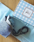 Two bonnet hats packaged in blue gingham Little Goodall box.