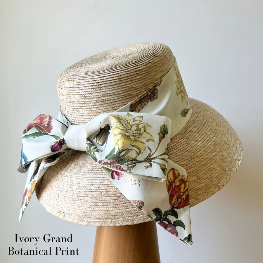Back view of straw hat with ivory floral middy bow hatband