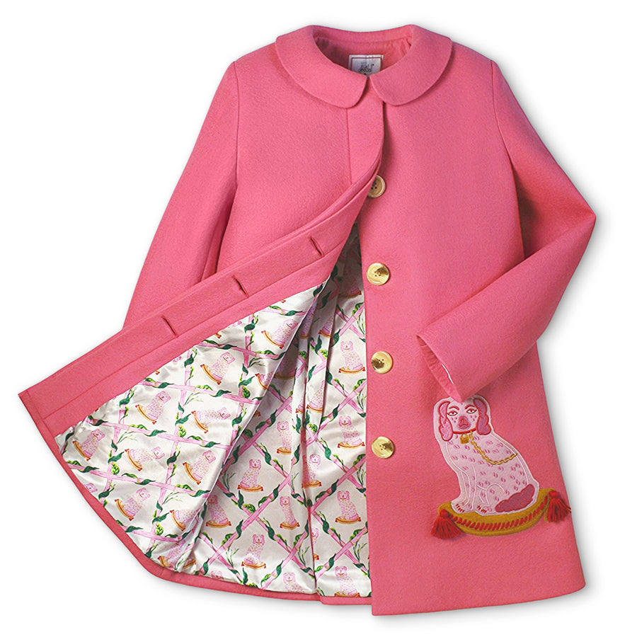 Pink merino wool A-line coat with embroidered dogs, gold buttons, and satin lattice print lining. Features hidden placket and back pleat detail.