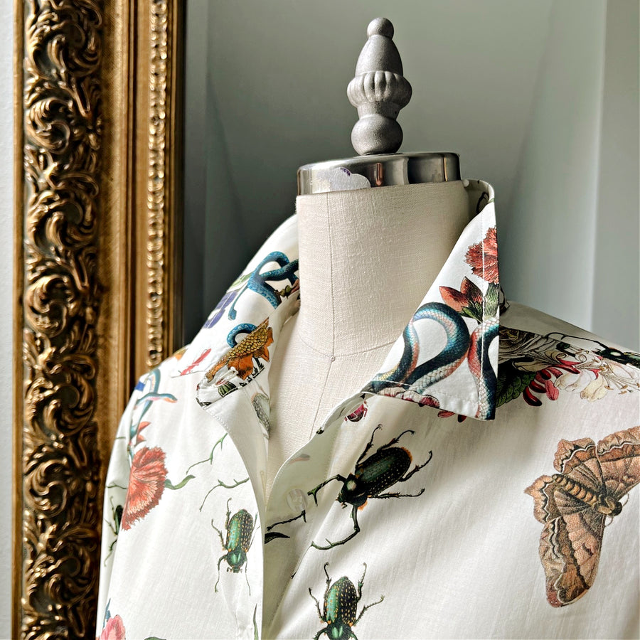 Close-up of botanical print shirt collar on mannequin, featuring floral and insect design