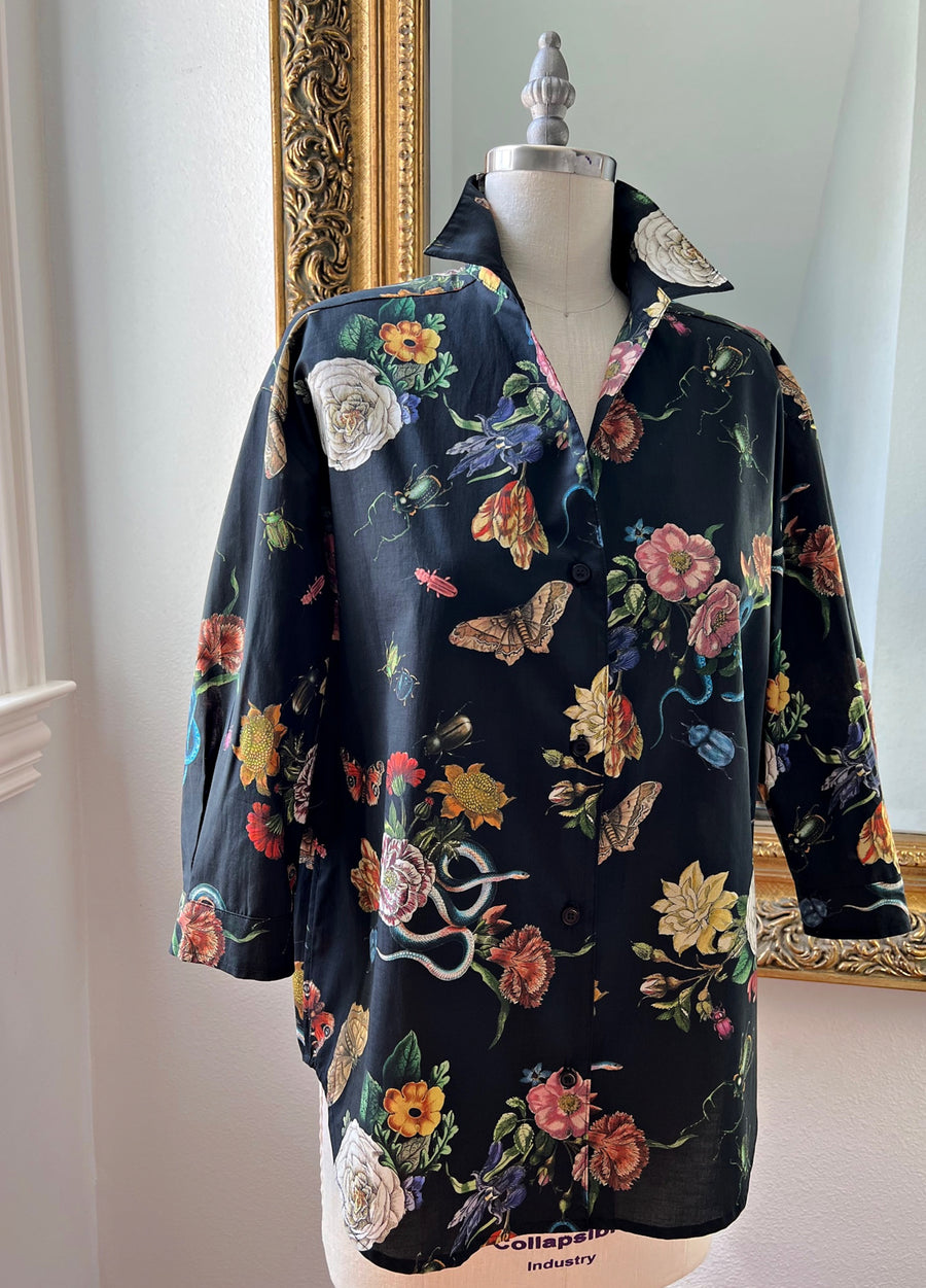 Little Goodall Midnight Grand Botanical Shirt displayed on a mannequin, showcasing its black cotton sateen fabric with a floral and insect print