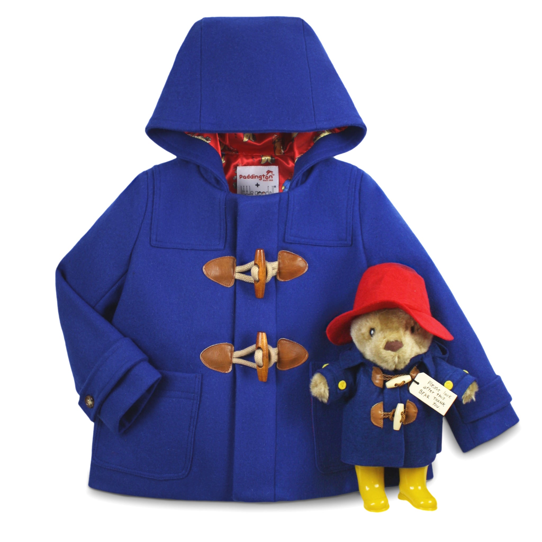Gift Sets; a royal blue wool toggle coat with wooden fastenings, red satin lining, and a hood, plus a 10" Paddington Bear plush 