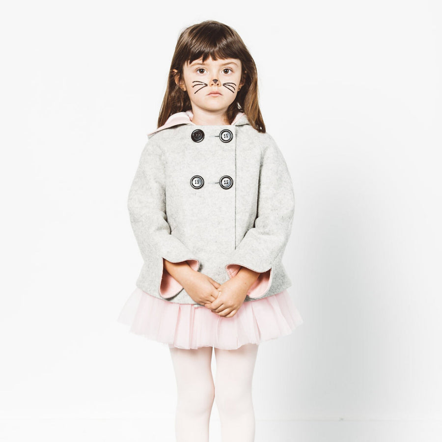 Girl wears a grey bunny coat with pink-lined cuffs, a cozy hood, and double-breasted buttons, styled with a pink tutu and tights.