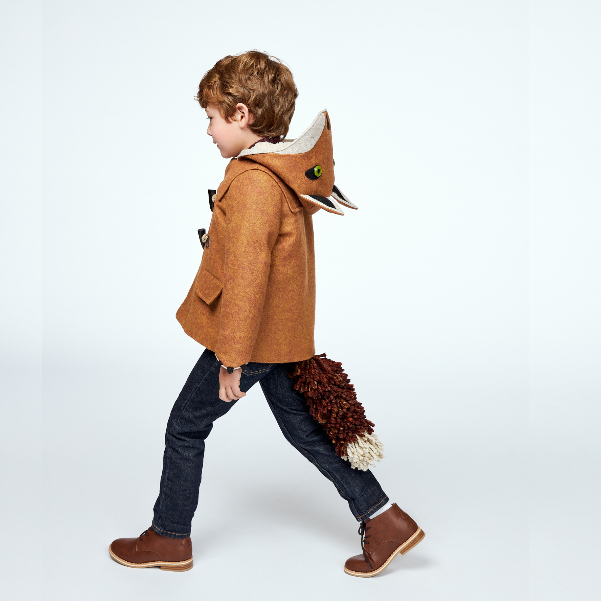 Child walking in a brown wool fox coat with a hood featuring fox ears and a detachable fox tail