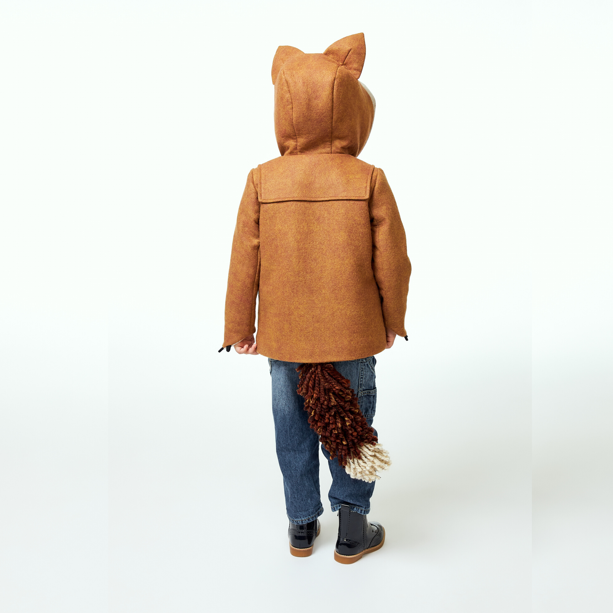 Child facing away, wearing a brown wool fox coat with pointed hood ears and a detachable fox tail.