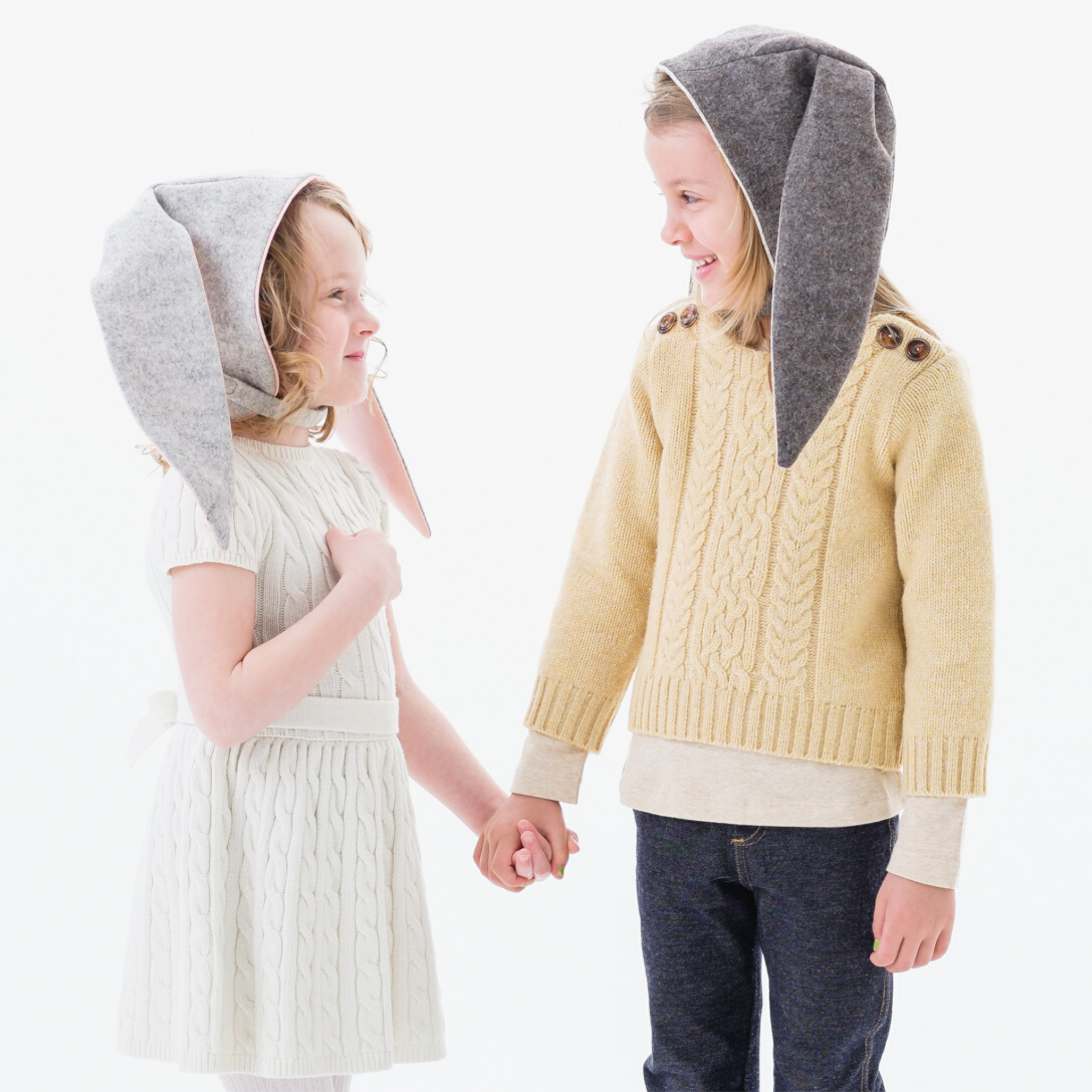 Child wearing the Luxe Grey Bunny Hat, featuring floppy ears, an adjustable velcro chin strap, and a soft fleece lining