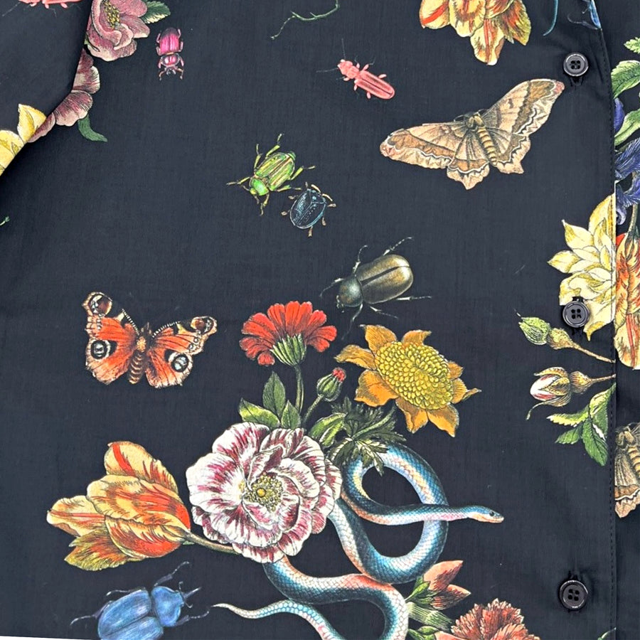 Close-up of the Midnight Grand Botanical Shirt showcasing detailed floral print with butterflies, beetles, and a blue snake on black cotton fabric