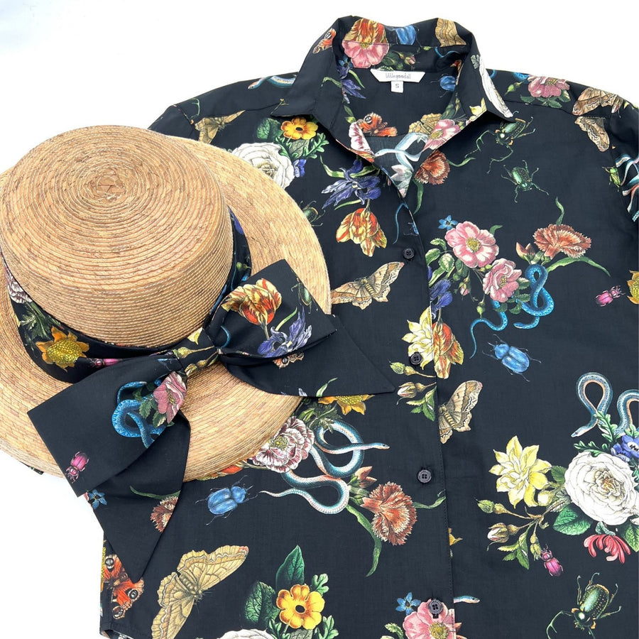 Midnight Grand Botanical Shirt laid flat with a matching straw hat featuring a fabric bow in the same floral and insect print.