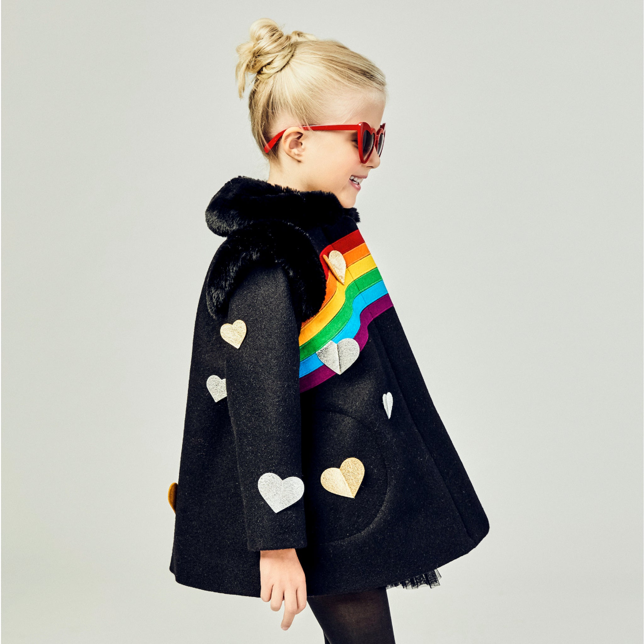 Girls' black winter coat with rainbow detail, faux fur collar, and gold and silver heart appliqués