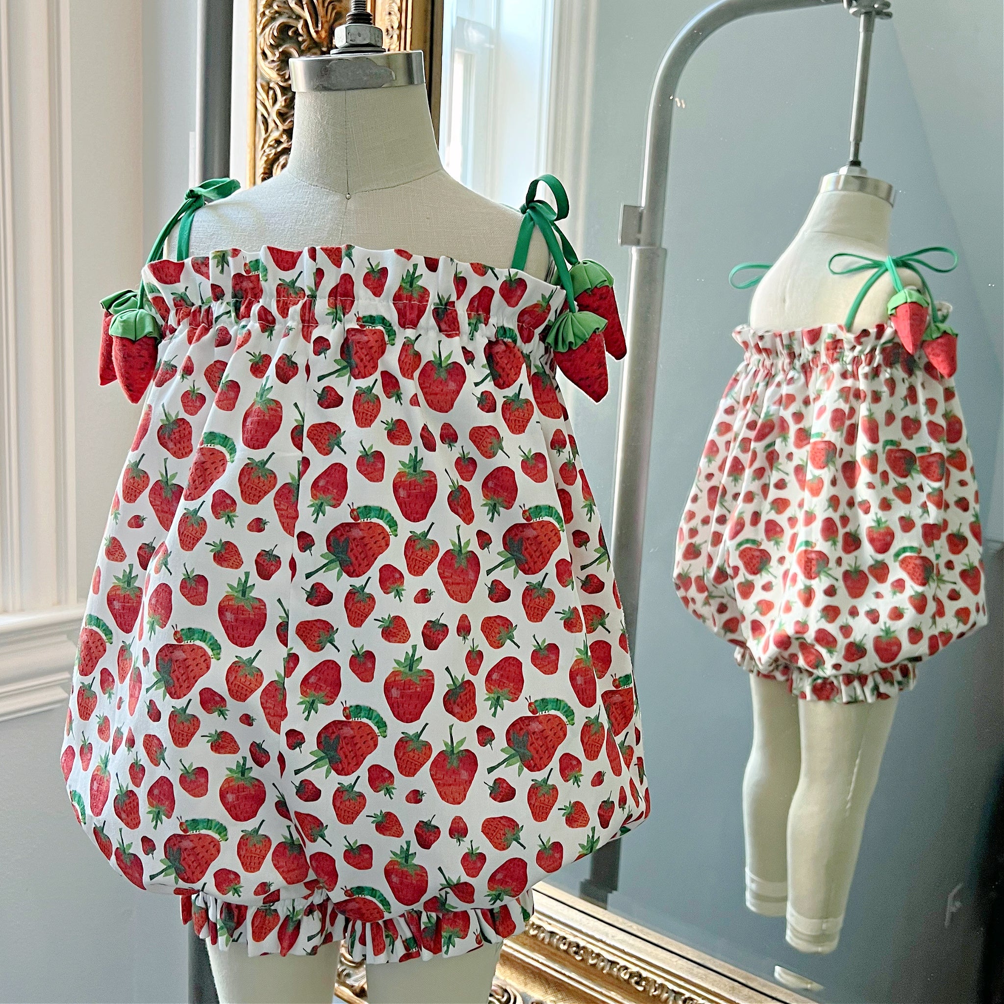 Strawberry bubble romper with Eric Carle’s Very Hungry Caterpillar print, tie-shoulder straps, and ruffled trim.