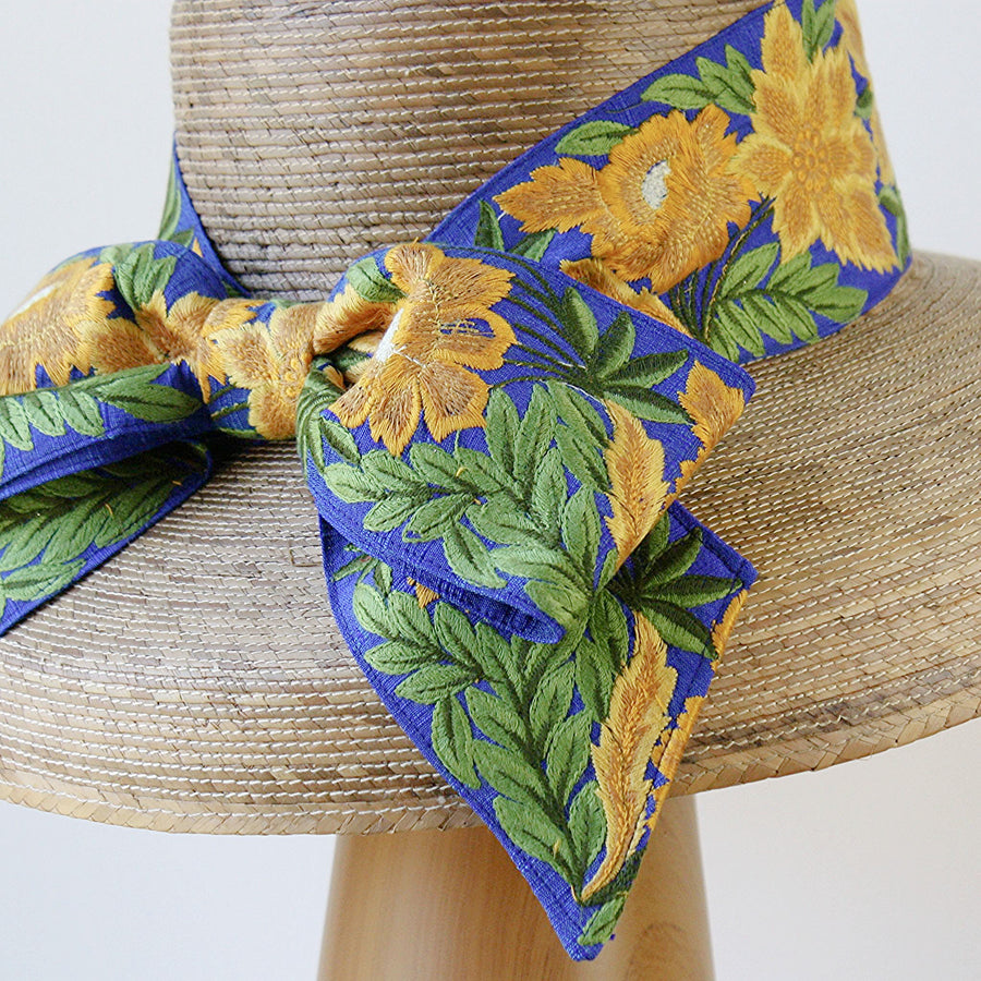 Close-up of French blue embroidered sunflower bow on the back of Audrey Sunflower straw hat