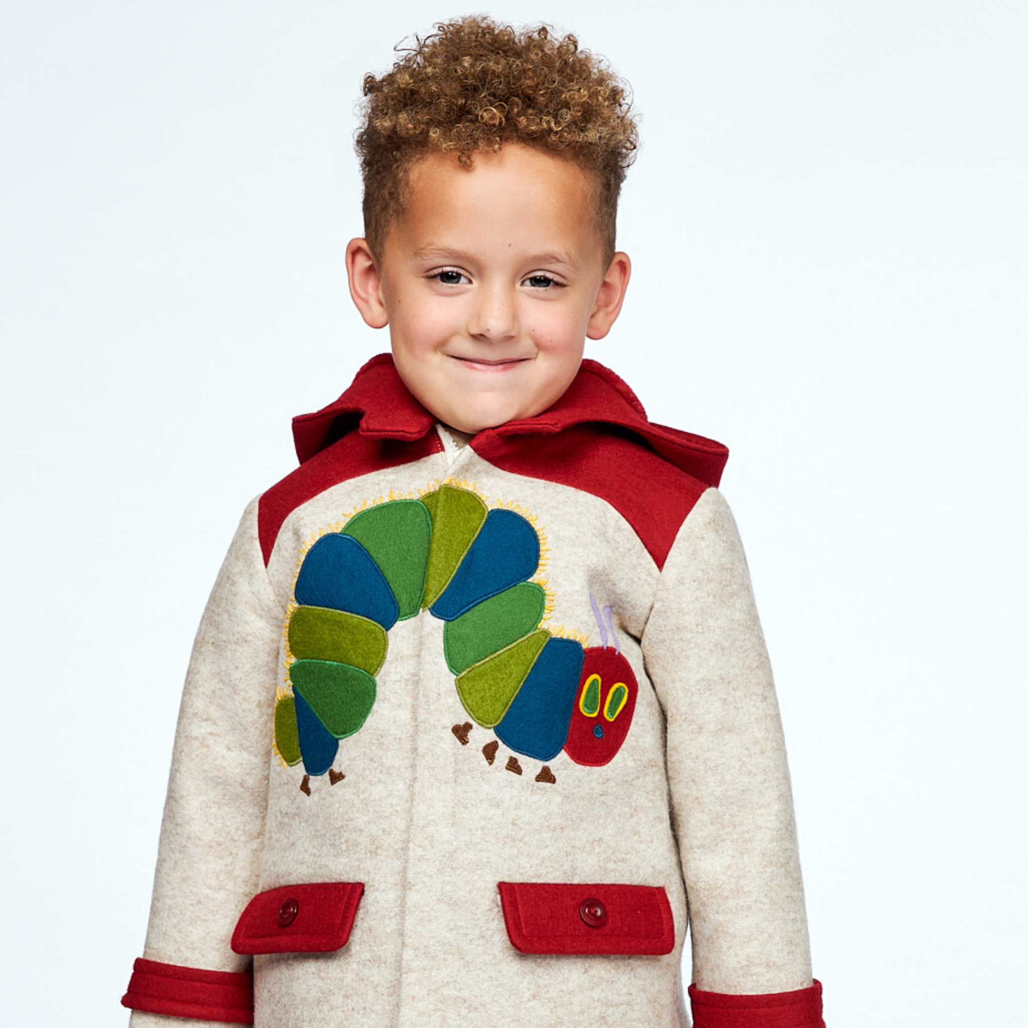 Child wearing a warm wool coat with a Hungry Caterpillar appliqué, red hood with antennae, and functional pockets, designed for toddlers and kids