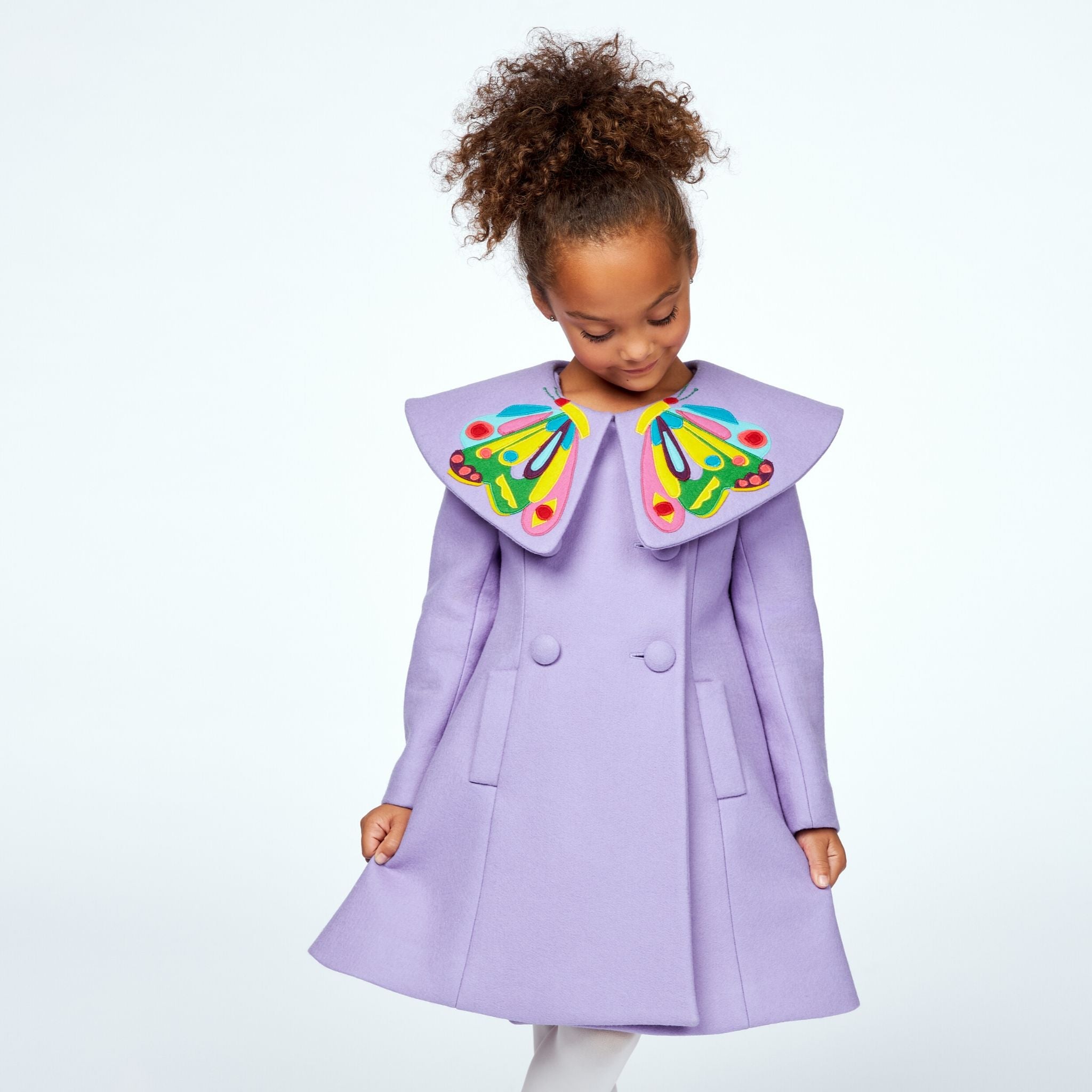 Girls' purple coat featuring a butterfly collar inspired by The Very Hungry Caterpillar, double-breasted buttons, and a flared silhouette