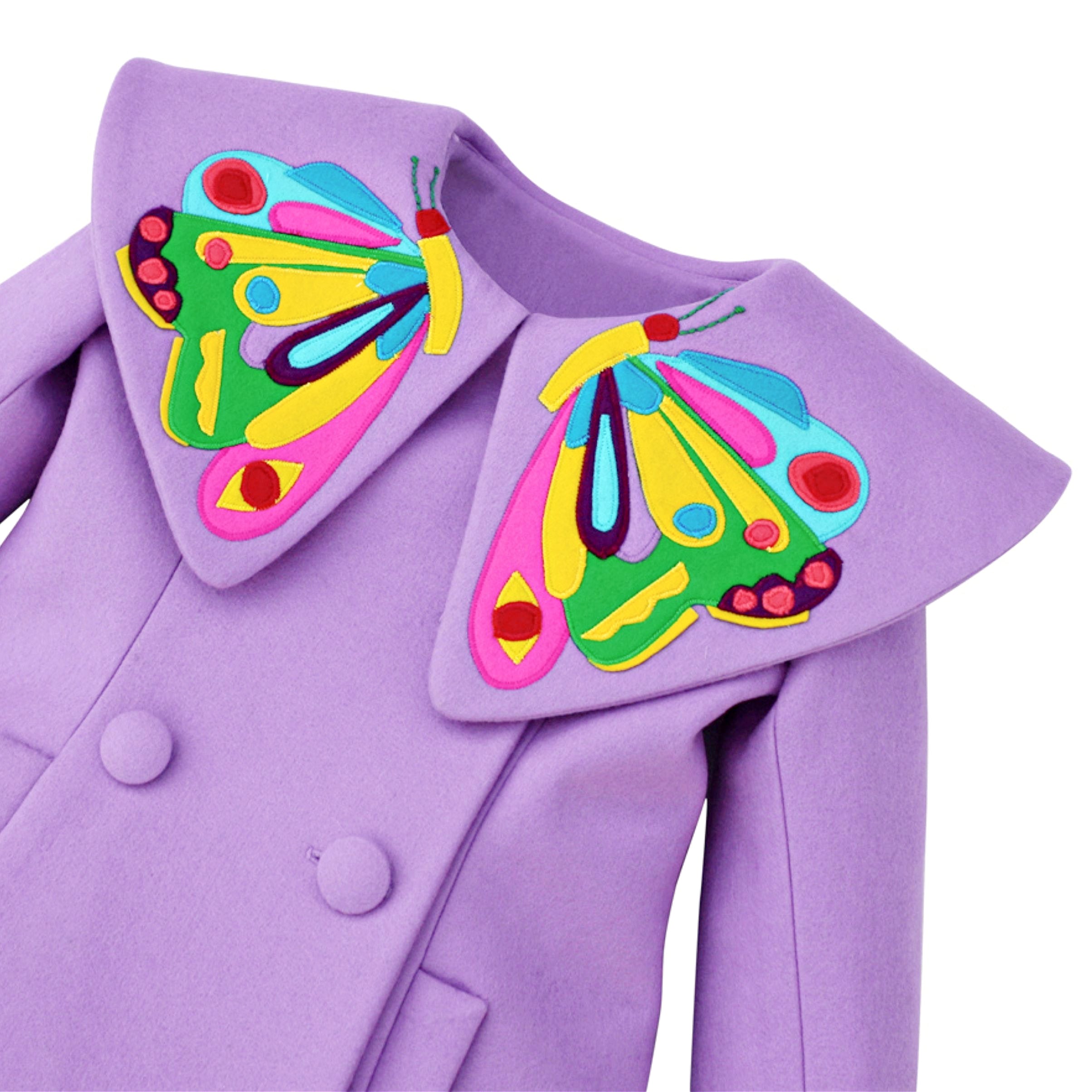 Close-up of a purple wool coat with a large butterfly-shaped collar featuring colorful embroidered details 
