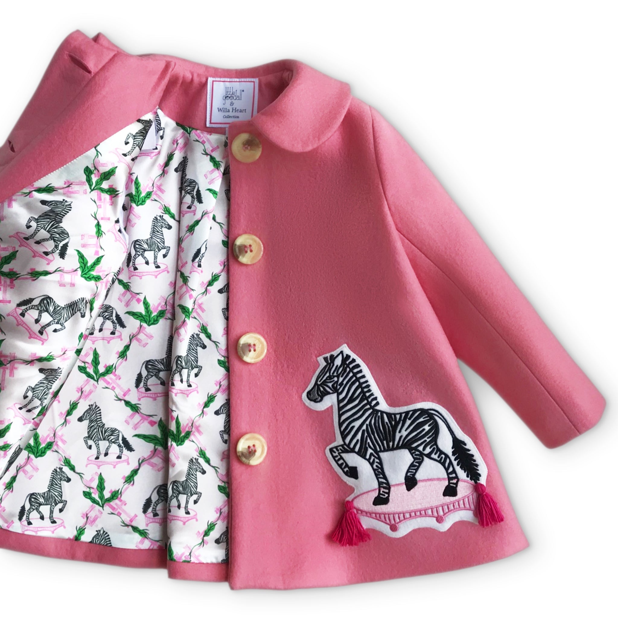 Yolanda and Tatty pink wool coat with zebra appliqué, gold buttons, and printed satin lining featuring zebras and greenery